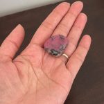 Holding a rhodonite crystal for manifesting.