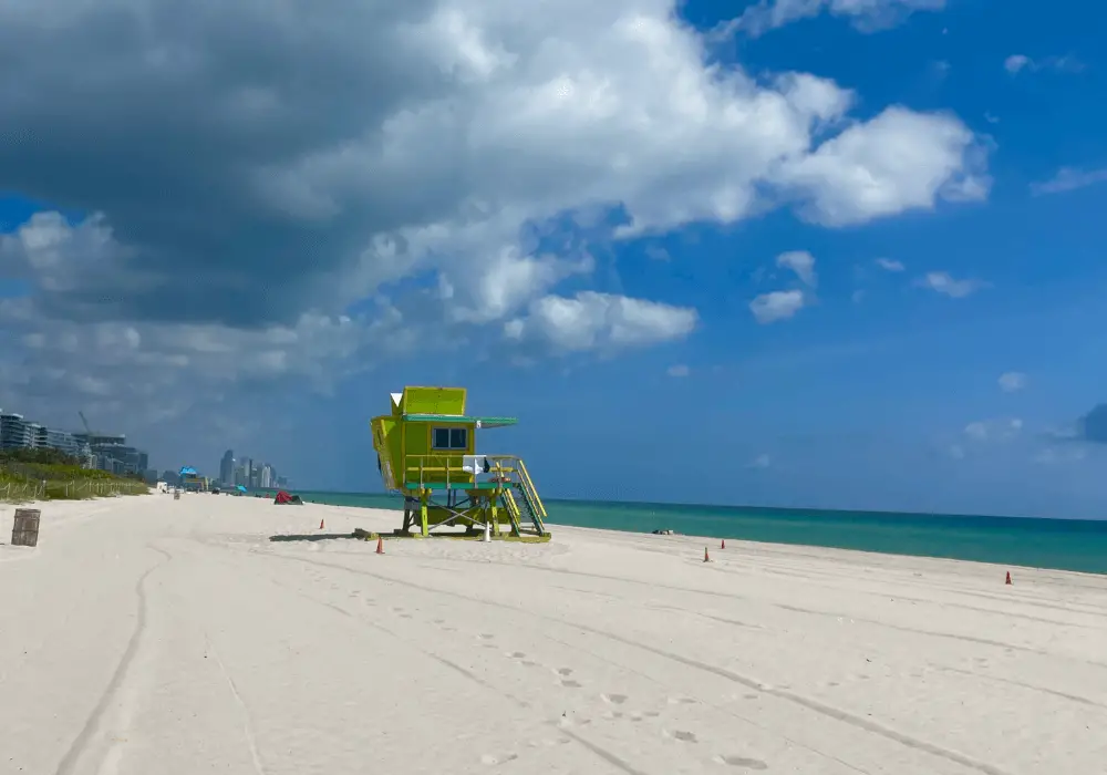 Author's personal photo of a lime green lifeguard tower in the middle of a pristine beach on a sunny day.